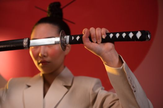 A Woman in Beige Suit Holding a Samurai
