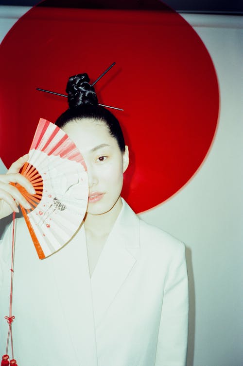 A Woman Covering her Face with a Hand Fan