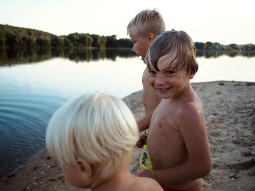 deniz kıyısı, erkek çocuklar, göl içeren Ücretsiz stok fotoğraf