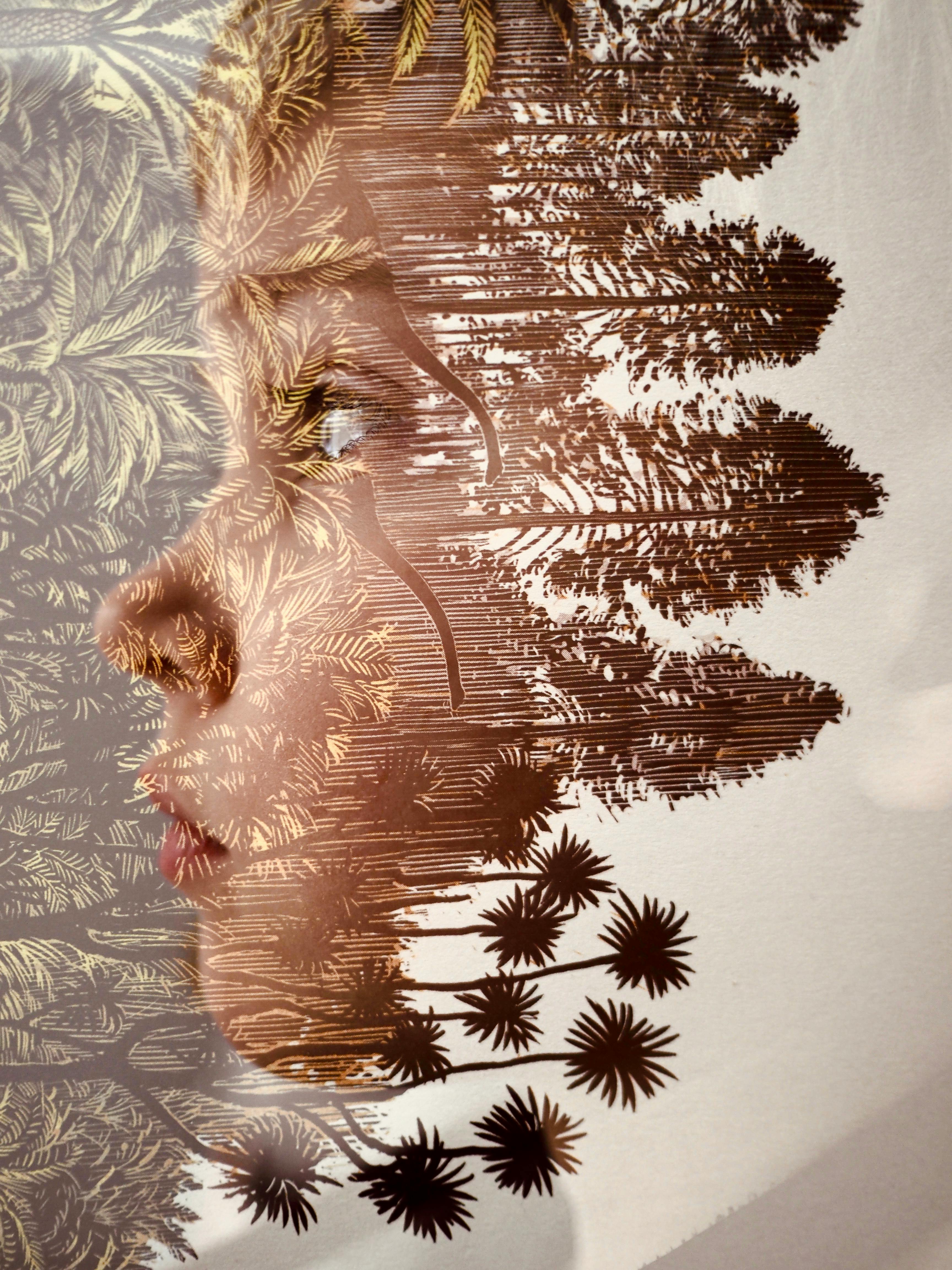 Artistic double exposure of a child's profile blended with natural elements, creating a whimsical portrait.