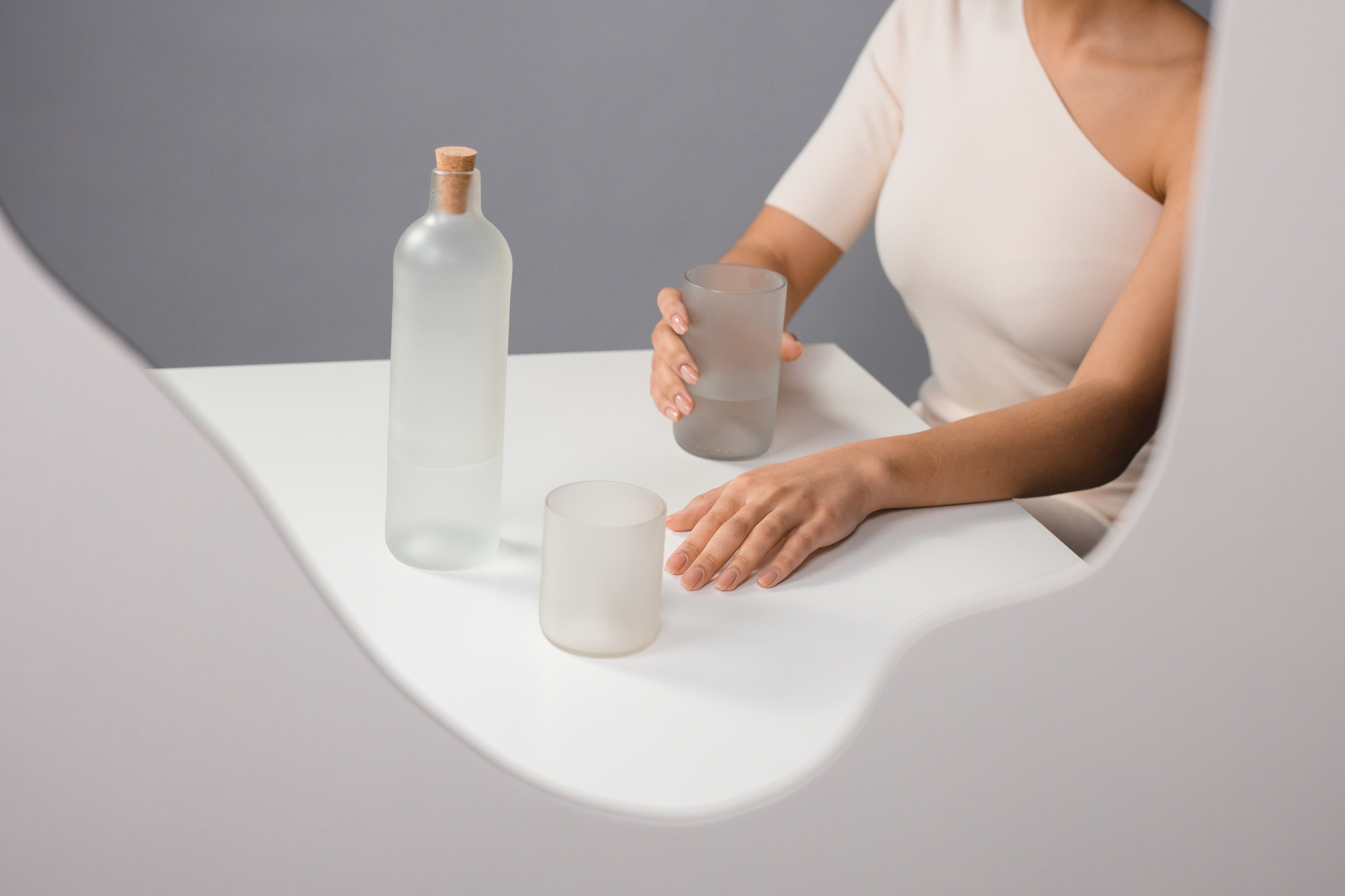 Frosted glass bottle and drinking glass of clean water