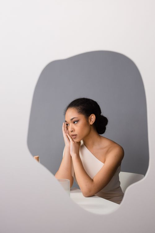 Free Elegant portrait of a woman gazing into a mirror, showcasing minimalist style and introspective mood. Stock Photo
