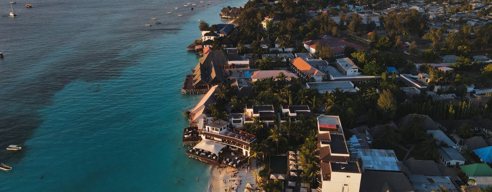 Stunning aerial photograph of Nungwi Beach, Zanzibar capturing the serene coastline at sunset.
