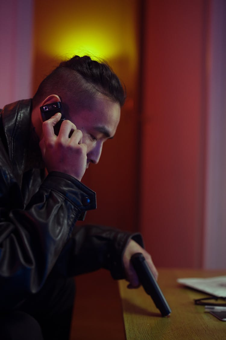 A Man In Black Leather Jacket Talking On The Phone