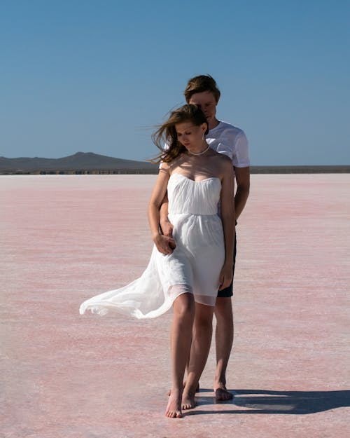 A Couple Standing Barefooted while Embracing Each Other