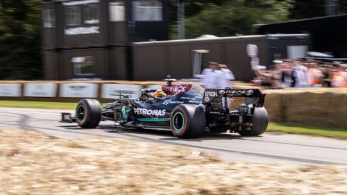 Free Mercedes Formula One car racing at high speed on an outdoor track in England. Stock Photo