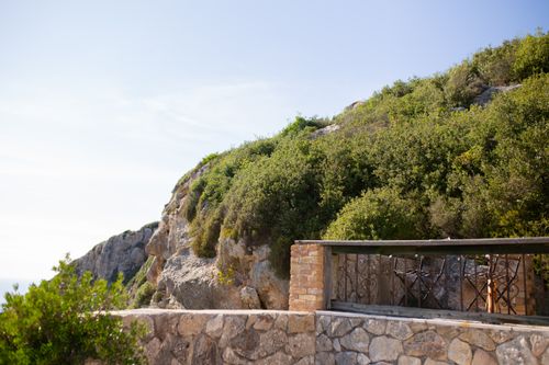 Free Scenic view of a cliffside terrace with lush greenery overlooking the sea. Stock Photo