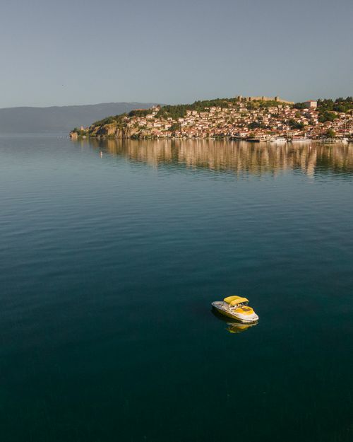 Free A tranquil scene with a boat on Lake Ohrid, capturing the serene beauty of North Macedonia. Stock Photo
