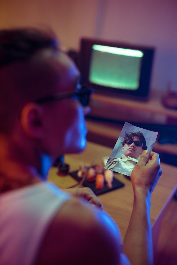 Close-Up Shot Of A Man Holding A Photo