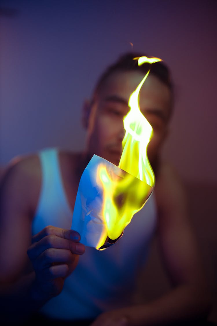 Close-Up Shot Of A Man Holding A Burning Paper