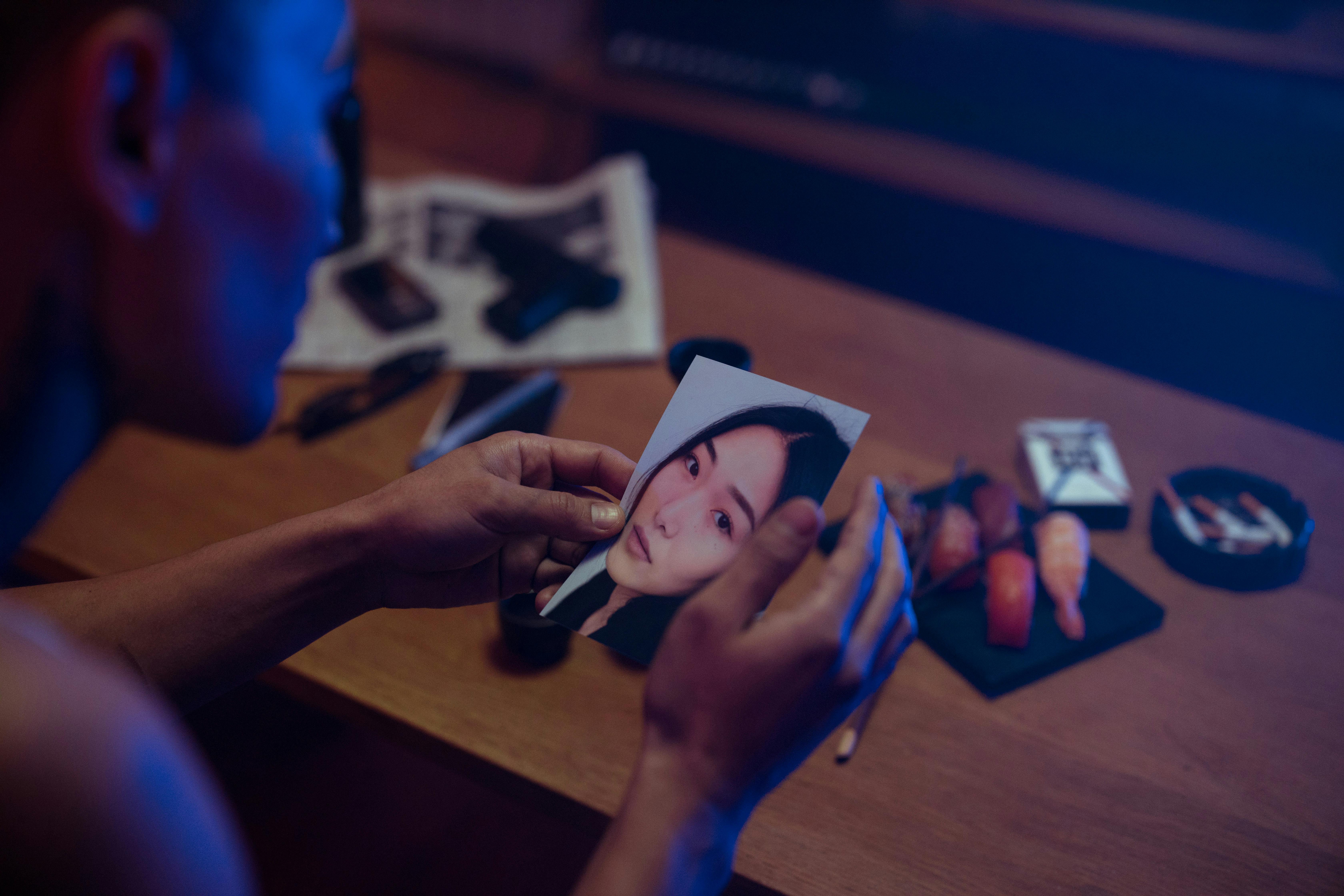 a man holding a picture of a woman