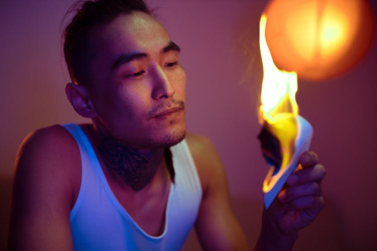 Close-Up Shot Of A Man Holding A Burning Paper