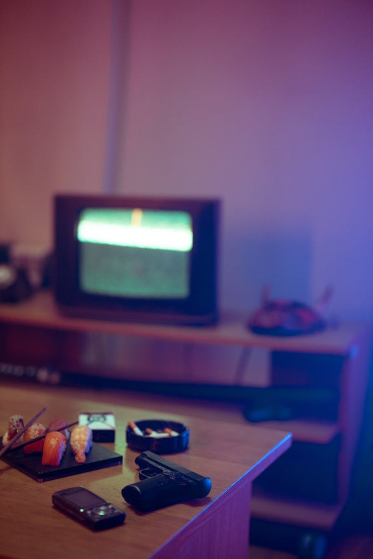 Room With TV, Gun, Sushi And Mobile Phone On Table