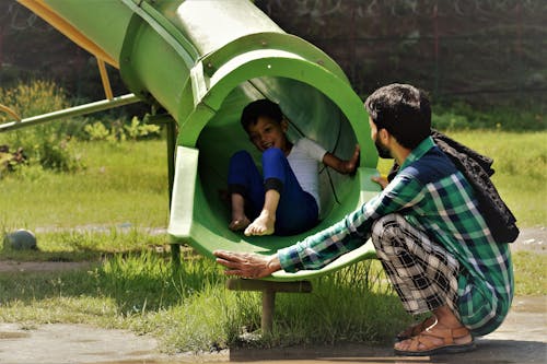 Free Father and Son Having Fun at Playground in Park Stock Photo