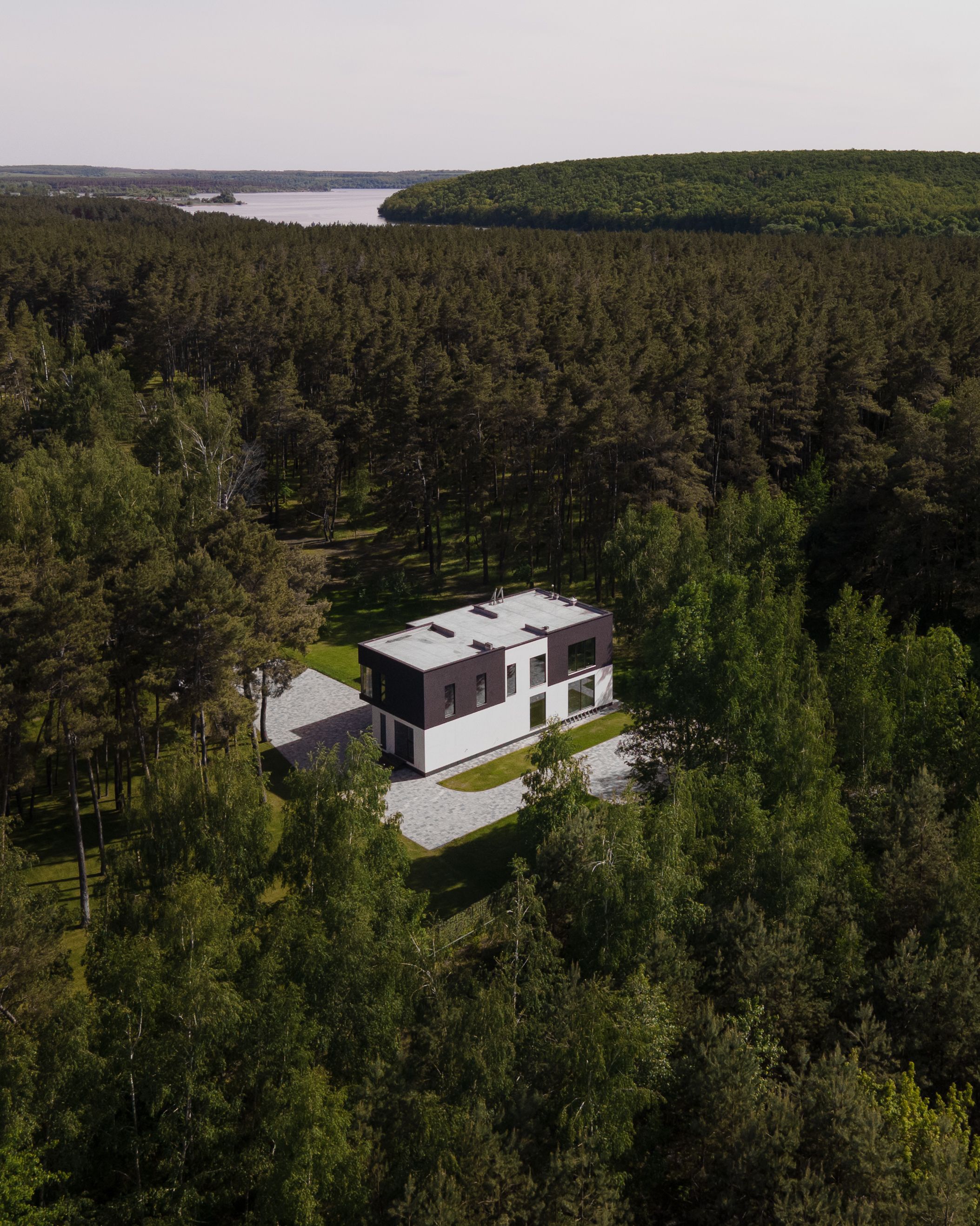 Aerial view of a modern house nestled within a dense forest in Solomino, Russia.
