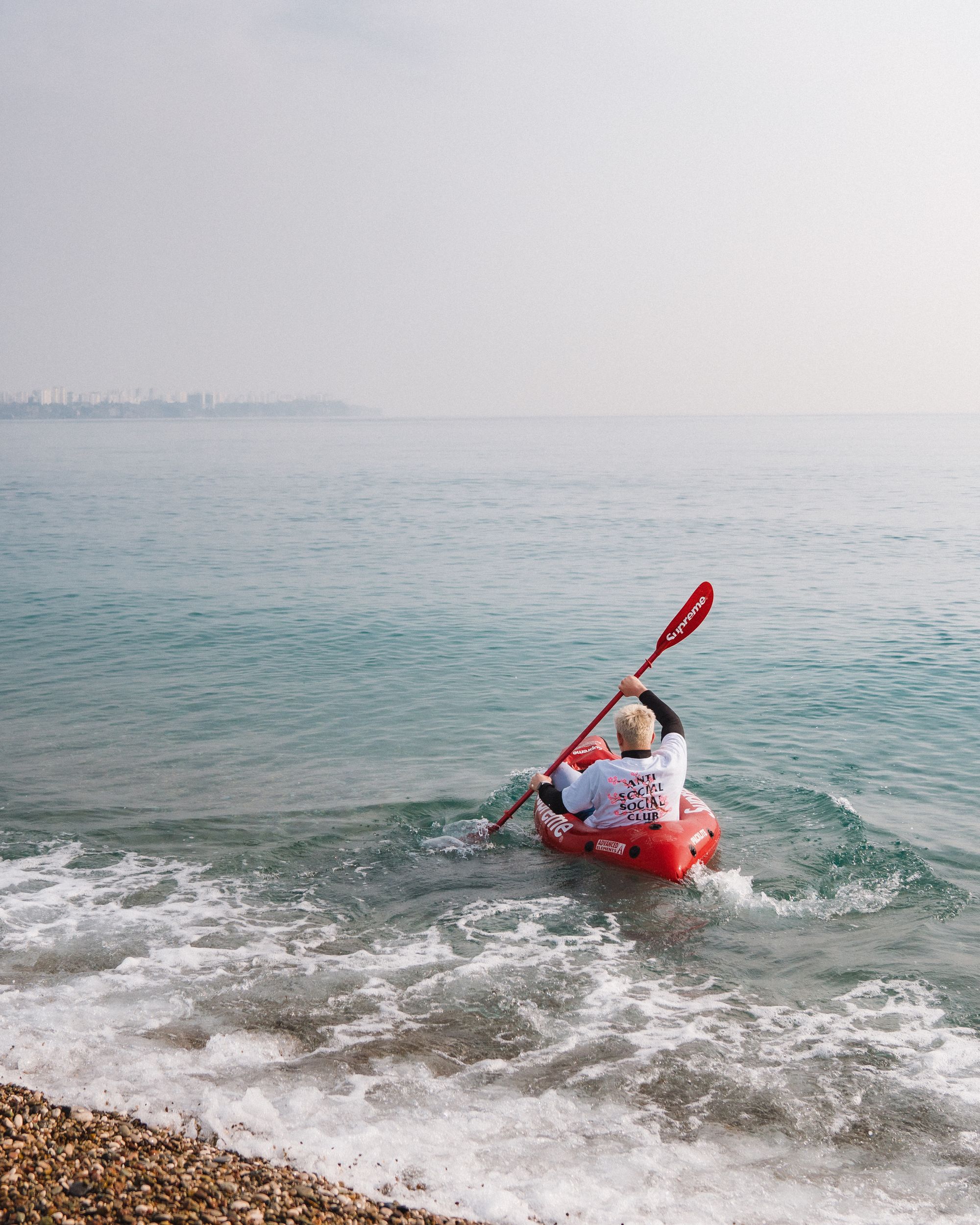 Kayaker paddling on calm coastal water during an outdoor recreation trip