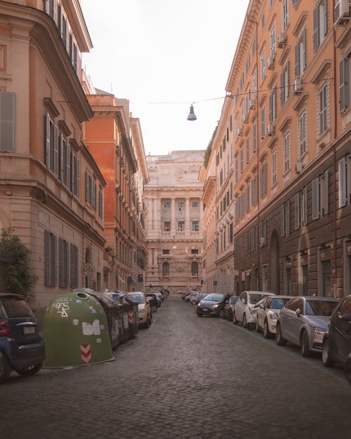 Cars Parked Beside Brown Concrete Buildings