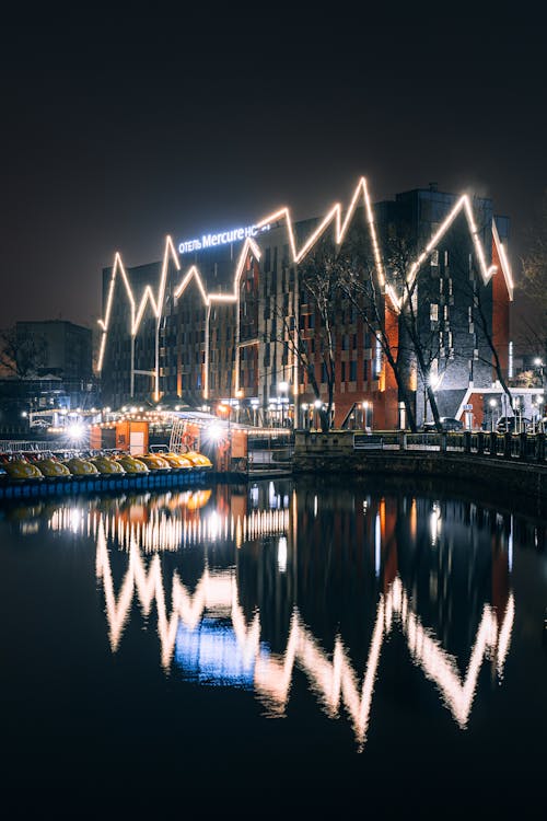 A Building With Illuminated Lights during Nighttime With Reflection on Water