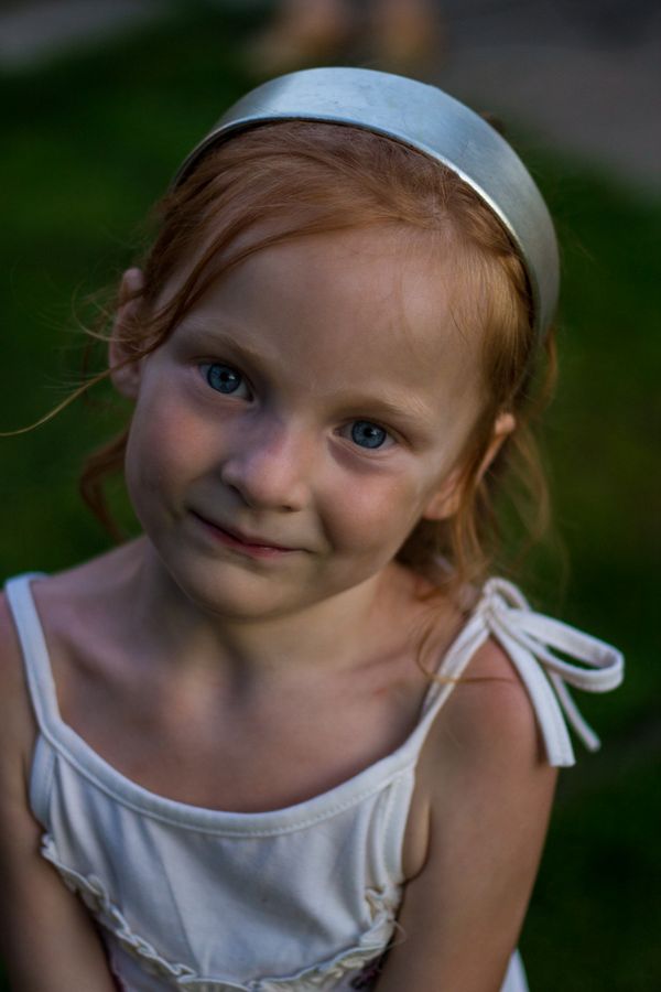 Little girl with red hair smiling at the camera