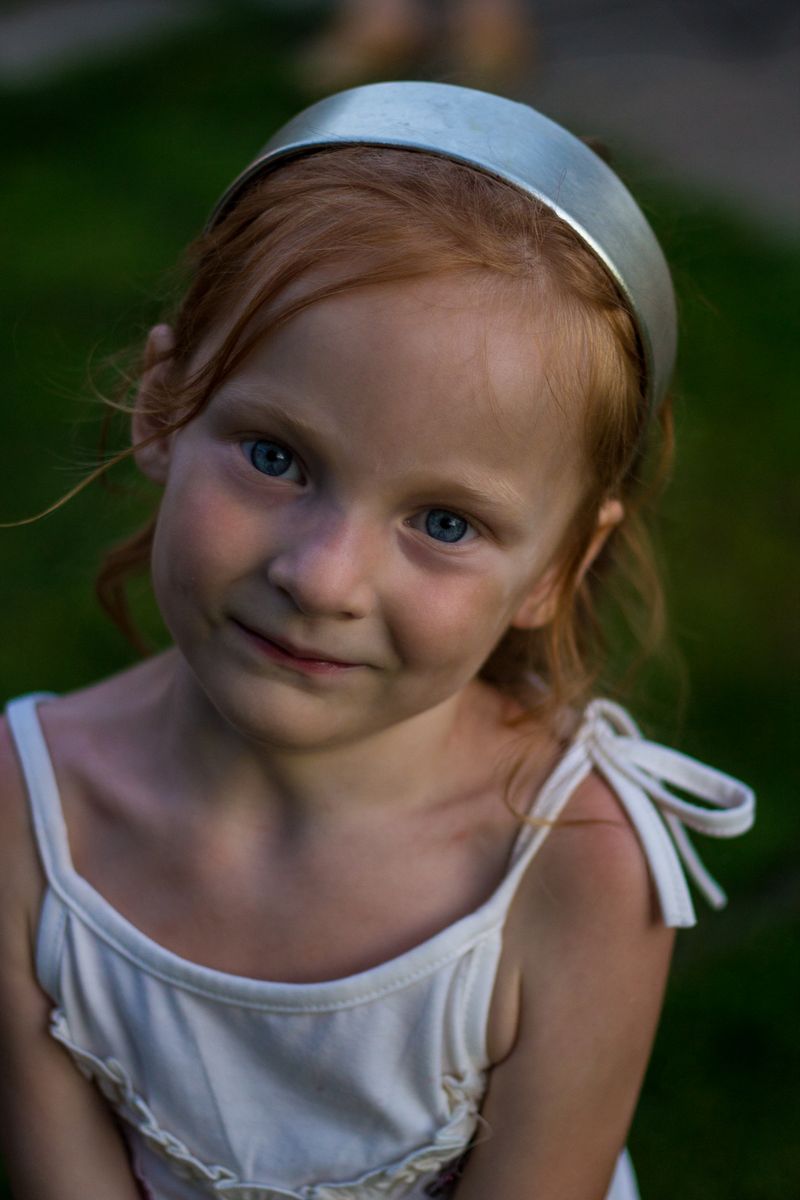Little girl with red hair smiling at the camera