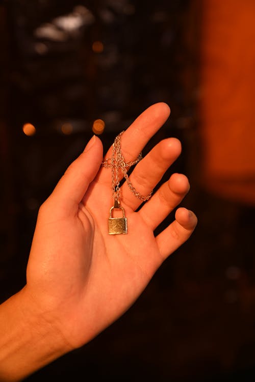 Free Close-Up Shot of a Person Holding a Gold Necklace Stock Photo