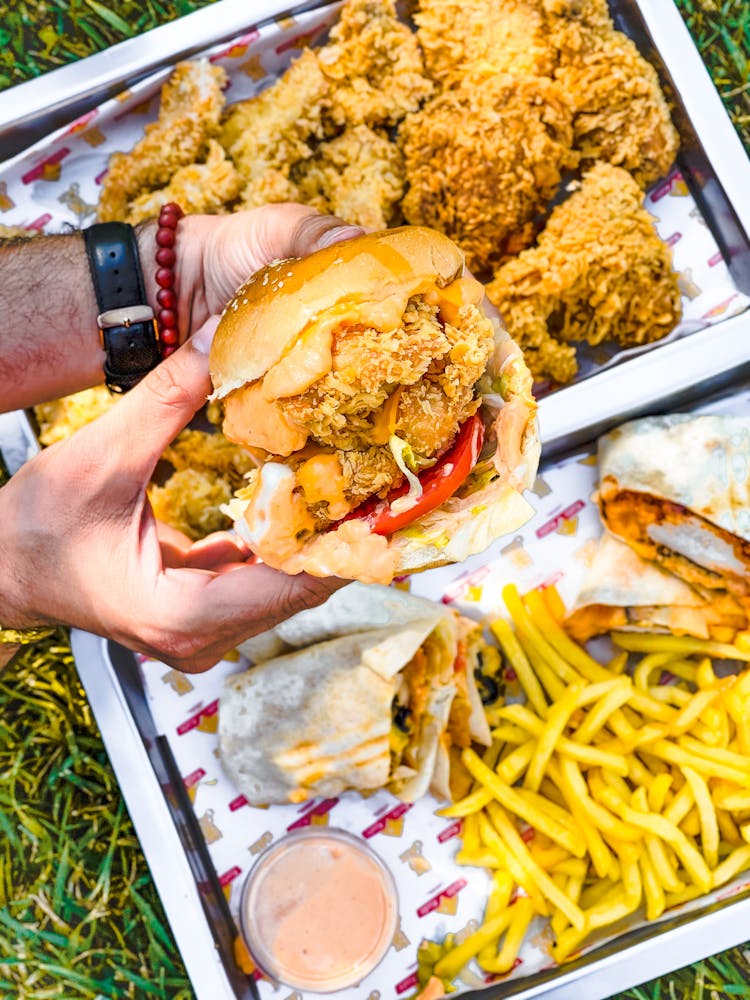 A Person Holding A Fried Chicken Sandwich