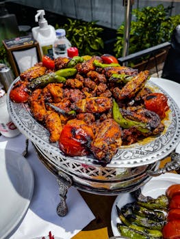 Delicious grilled chicken with roasted vegetables on a decorative platter outdoors.