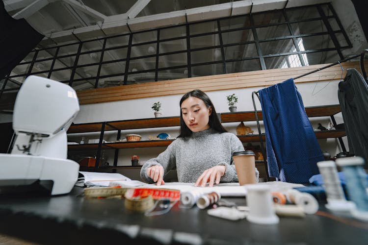 Woman Working At A Desk In A Sewing Studio 