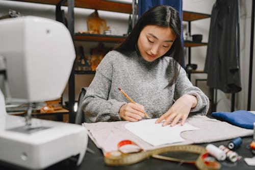 A Woman in Gray Sweater Holding a Pencil