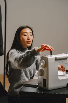 Focused woman operating sewing machine, symbolizing creativity and small business endeavor.