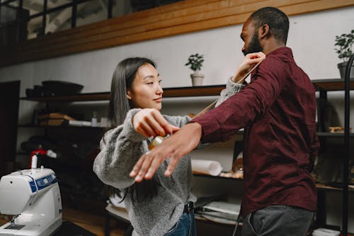 A Woman Measuring the Arm Length of a Man