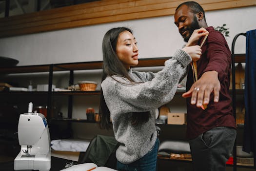 A fashion designer measuring a client's shirt size in a workshop setting with sewing tools.