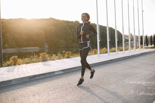 Free A woman jogging on a sunny outdoor path, showcasing fitness and sport. Stock Photo