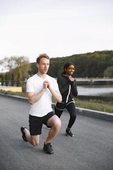 Two adults enjoying an outdoor warm-up session by the river, focusing on healthy fitness routines.