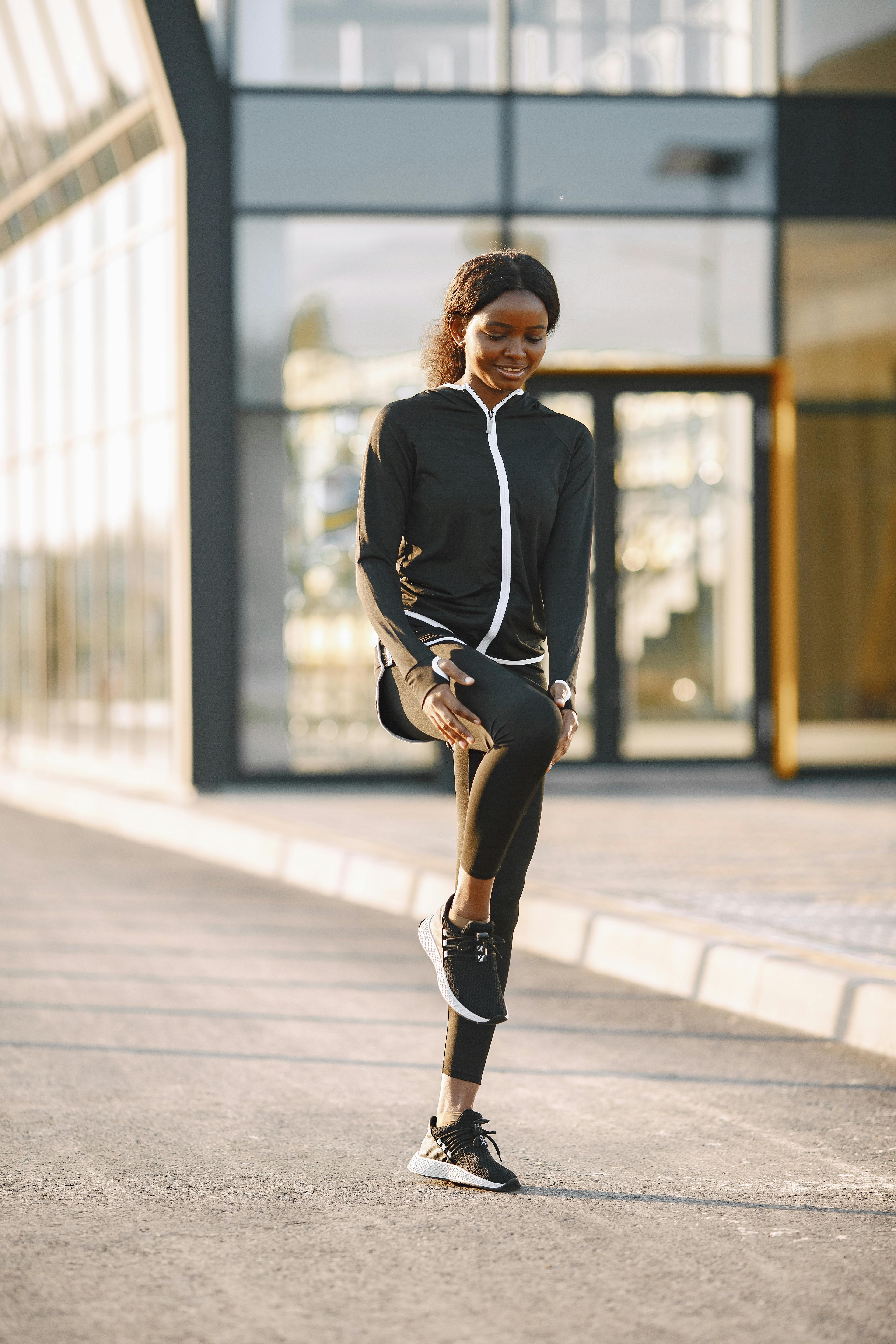 Woman in Black Jacket Stretching Her Leg · Free Stock Photo