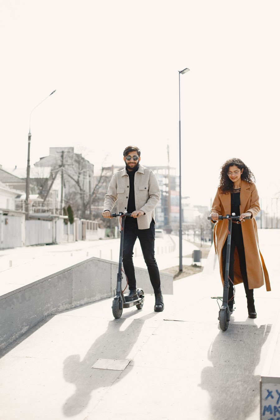Pareja circulando en patinetes eléctricos por la ciudad