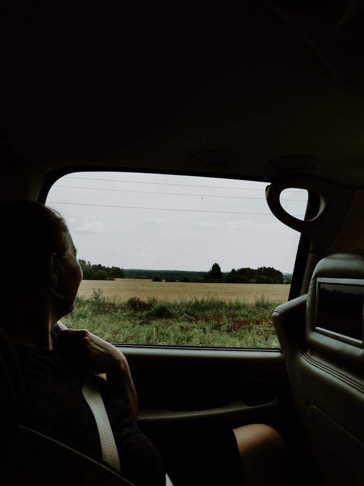 Woman Looking Outside A Car Window