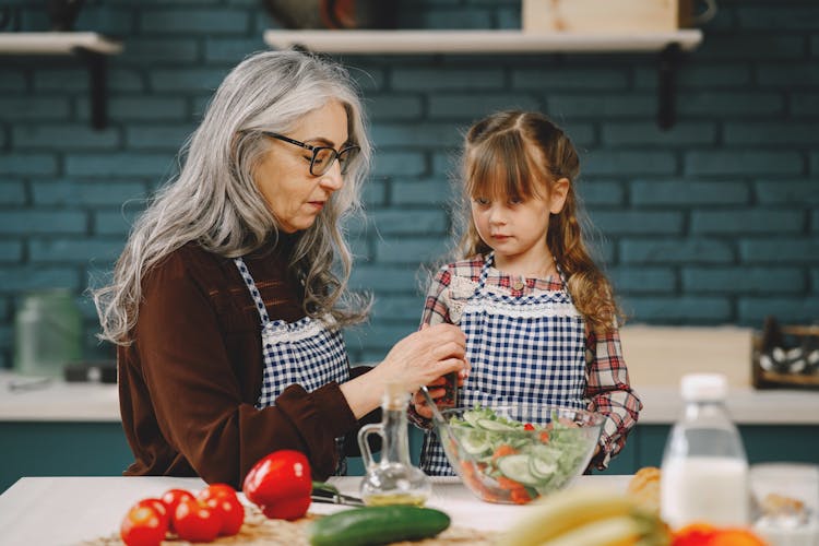 Elderly Woman Prepares Food Together With Her Grandchild