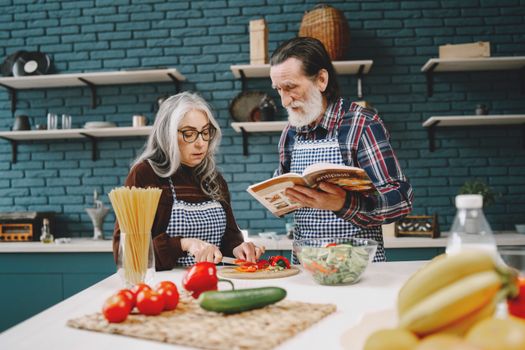 Elderly couple preparing a meal together in a stylish kitchen, emphasizing bonding and teamwork.