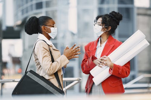Women wearing Face Masks talking with each other 