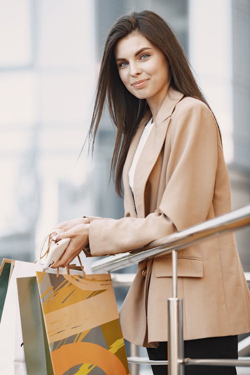 Free Photo  A business woman in a coat and suit, holding a bag in