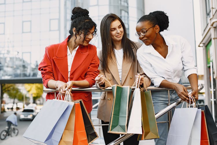 Happy Female Friends Carrying Shopping Bags