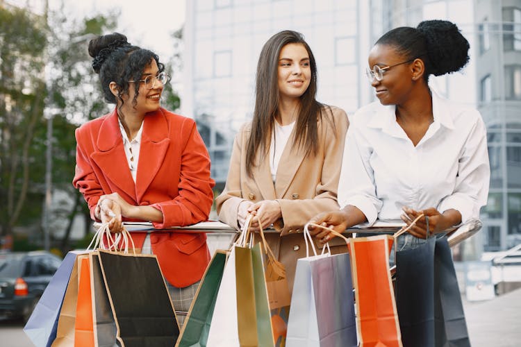 Happy Female Friends Carrying Shopping Bags