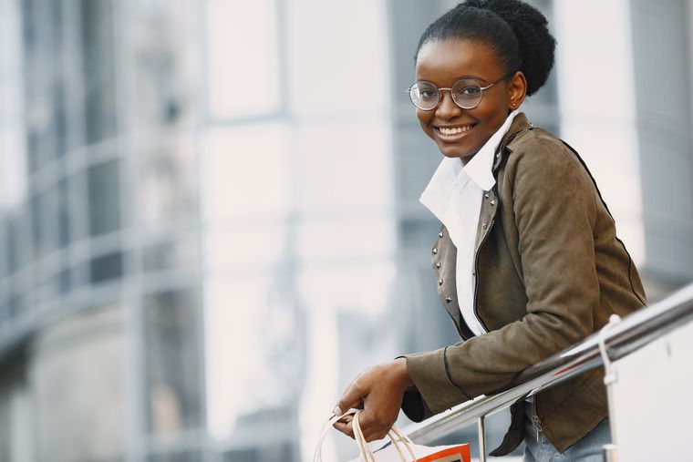 Smiling customer holding a paper bag, photo by Gustavo Fring on Pexels