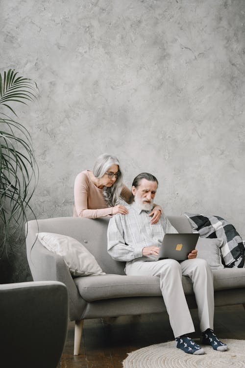 Man Using Laptop and Woman Looking at the Screen