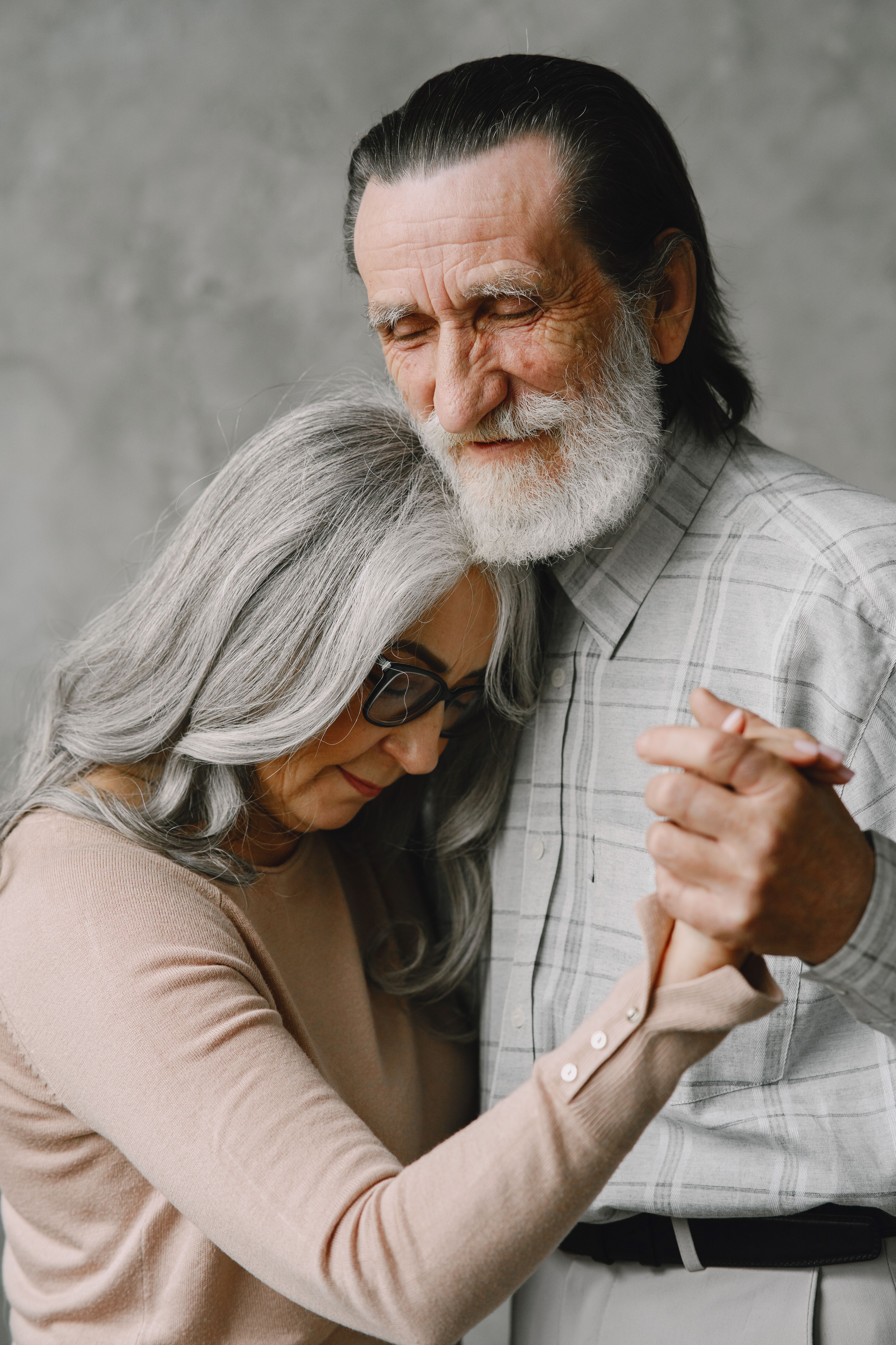 Heartwarming image of an elderly couple dancing together in a tender embrace, symbolizing love and togetherness.