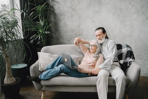 Free Happy Elderly Couple sitting on a Sofa  Stock Photo