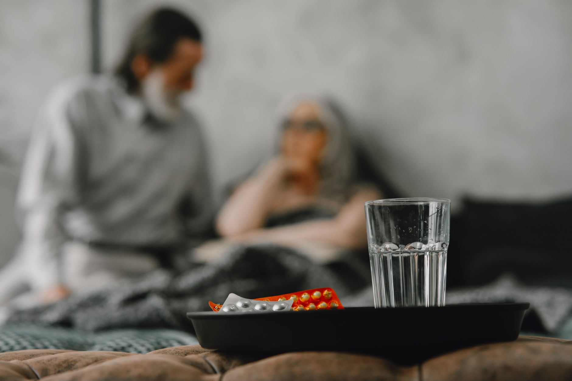 Elderly couple focuses on health support in a home setting with medications.