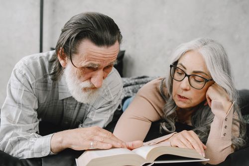 Free An elderly couple enjoying reading a book together, highlighting love and companionship. Stock Photo
