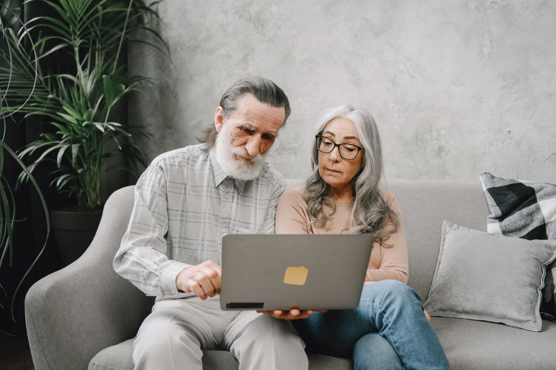 Older couple reviewing options side by side on a laptop